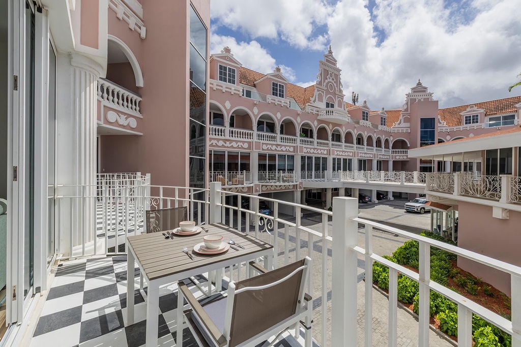 Sip your morning coffee on your private balcony while admiring the charming Dutch Colonial architecture and vibrant courtyard below.