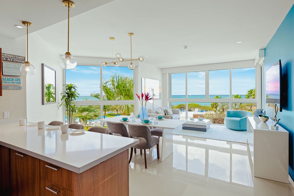 Relax in your bright, airy living space where stunning ocean views stretch beyond floor-to-ceiling windows, creating the perfect coastal retreat.