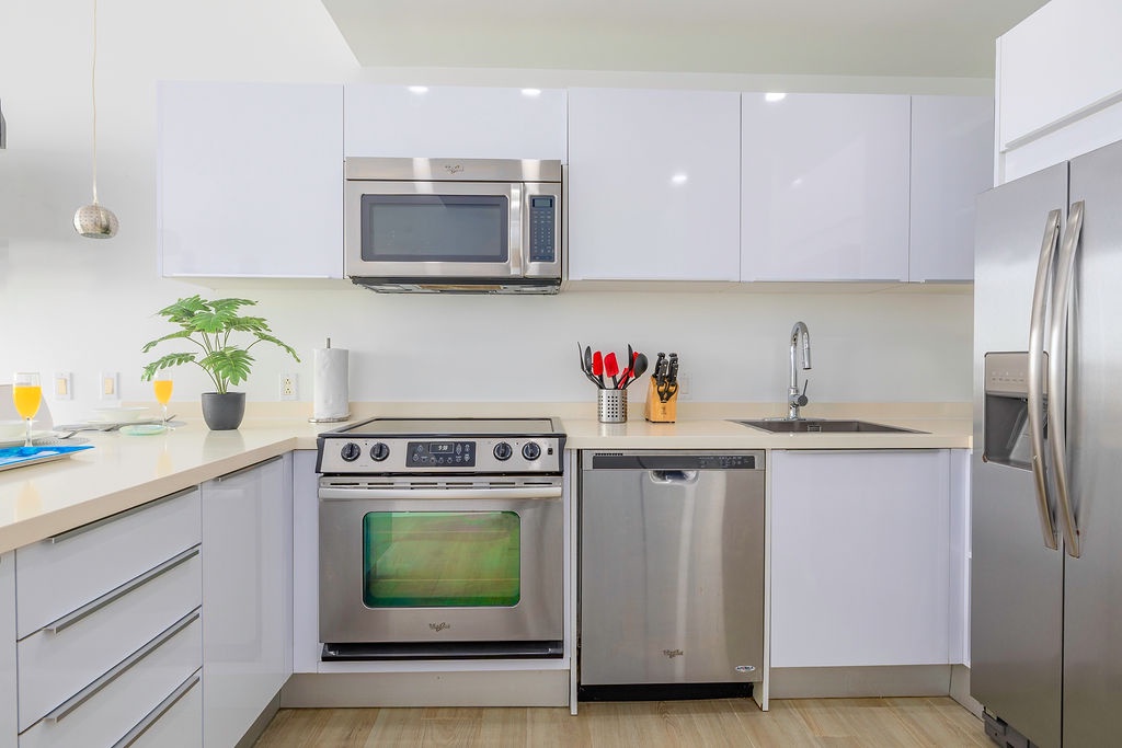 Your modern kitchen features sleek white cabinets, stainless steel appliances, and everything you need for culinary adventures.