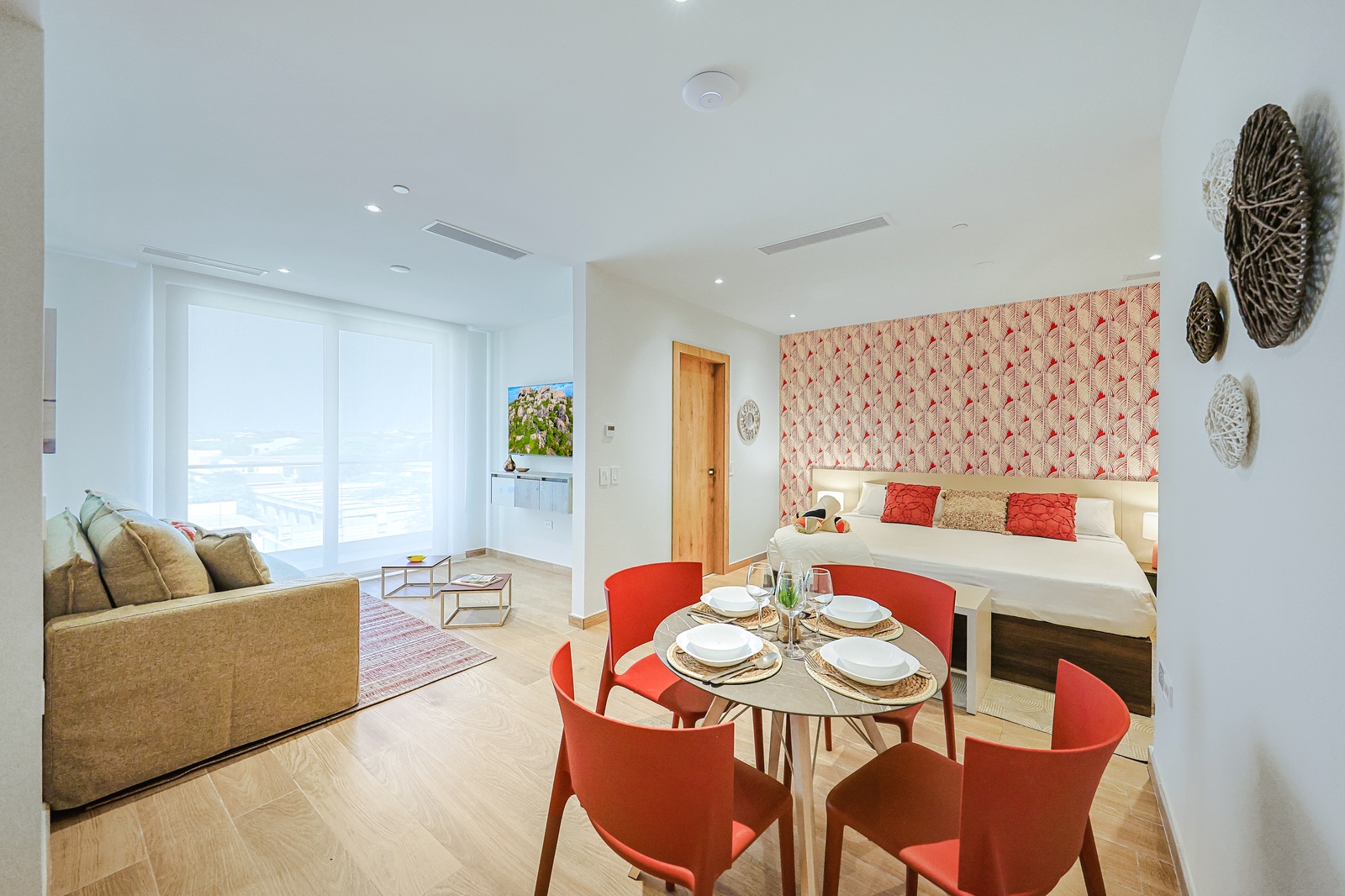 Relax in your bright, open-concept studio where coral accents and coastal decor set a cheerful tone, while the dining table invites shared meals.