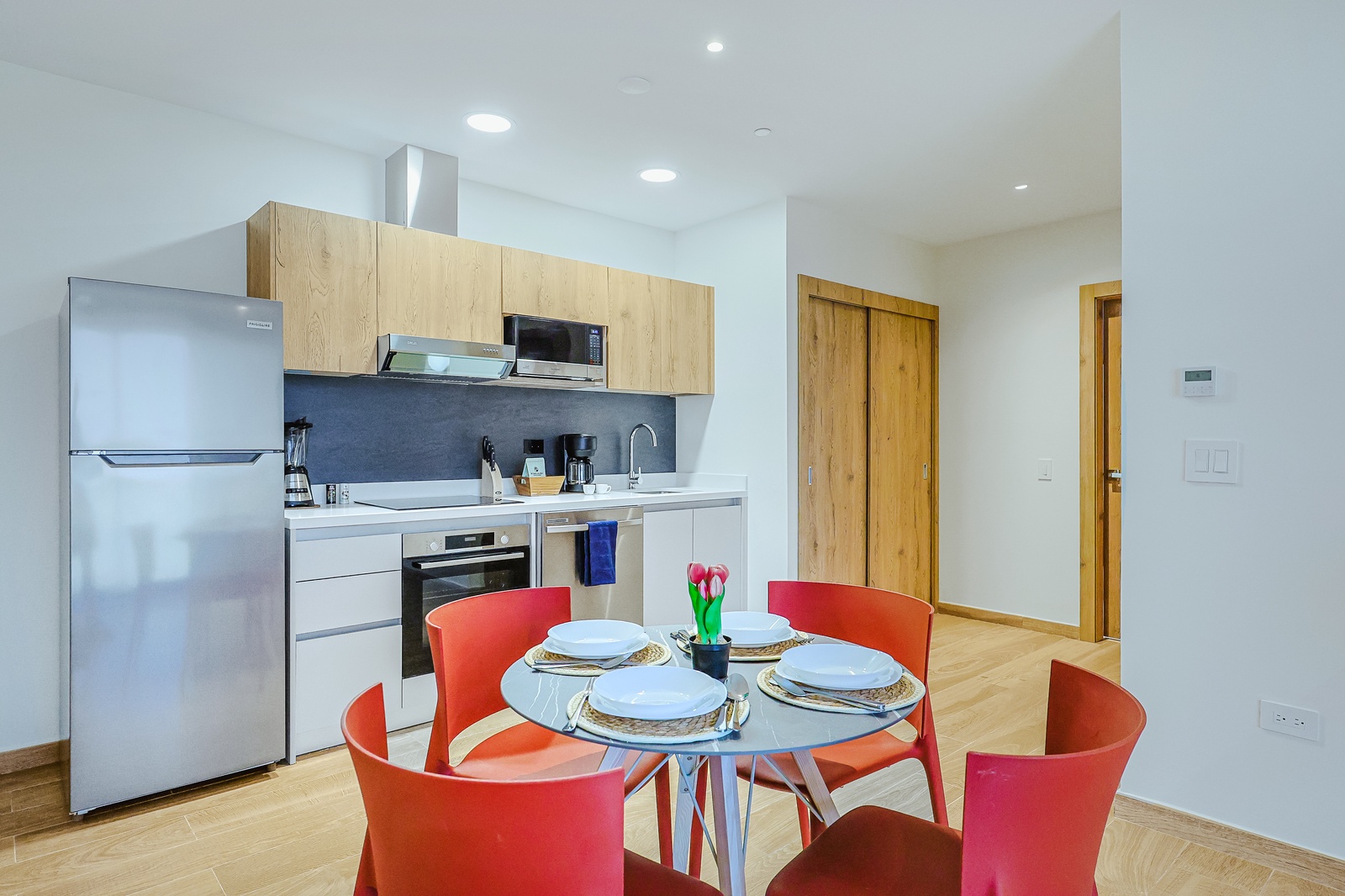 Step into your fully equipped modern kitchen and dining space, where bright natural light and sleek appliances invite you to prepare meals and gather around the cheerful table with ease.