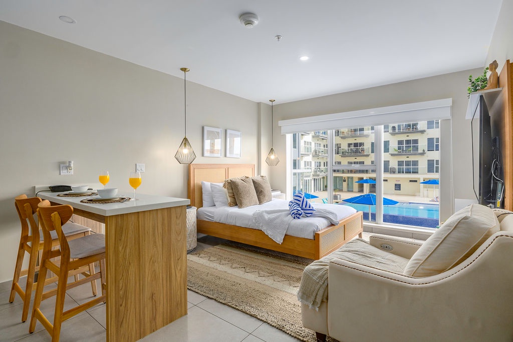 Relax in your modern studio with pool views, cozy seating, and breakfast bar—perfect for unwinding after exploring the city.