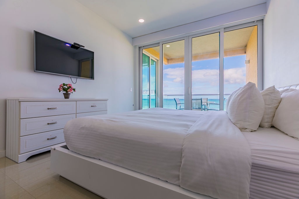 Master bedroom w/ king size bed and balcony access