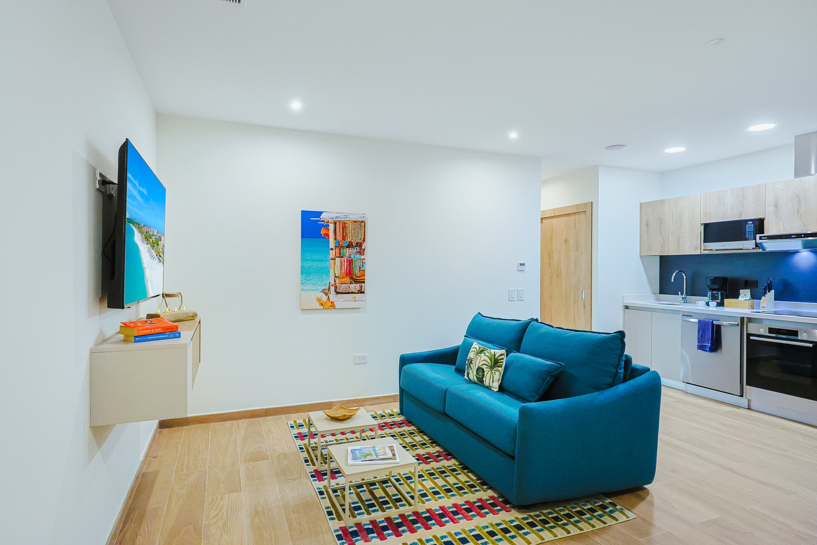 Unwind on the plush turquoise sofa with your favorite show, surrounded by bright, modern touches and an open flow into your sleek kitchen.