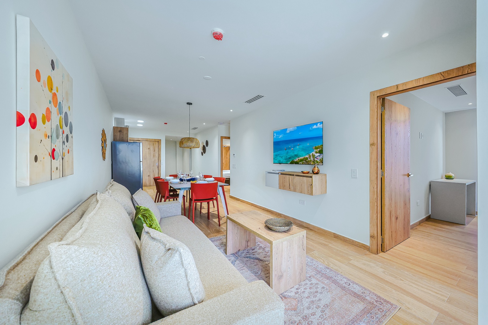 Settle into your bright, open living space where natural wood tones and airy design create an instant sense of calm. The plush sofa invites relaxation, while the adjacent dining area is ready for shared meals and laughter.