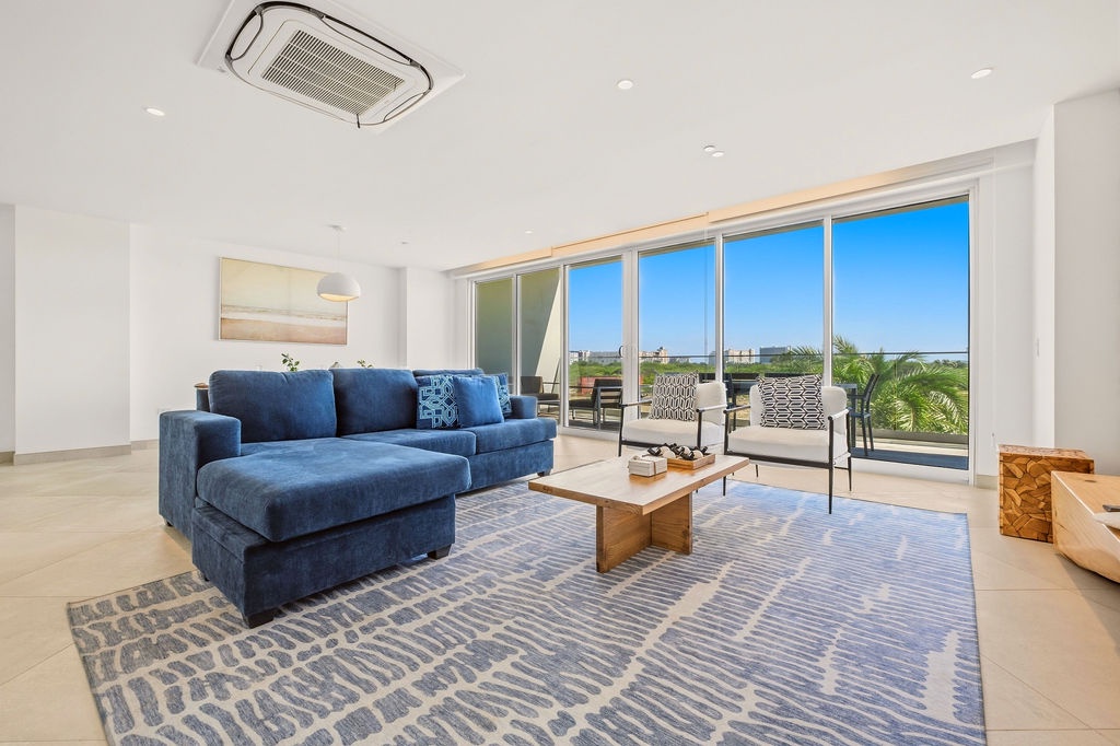 Sink into the plush blue sofa and let the sun-soaked terrace views draw you in. Natural light floods the space, while the seamless indoor-outdoor flow invites you to step outside and unwind in your own private retreat.