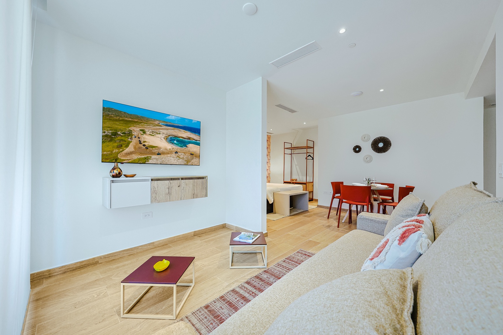 Your bright, open living space flows seamlessly into a dining area, offering a modern retreat with warm wood floors and clean, inviting design. Perfect for unwinding after a day of exploring.