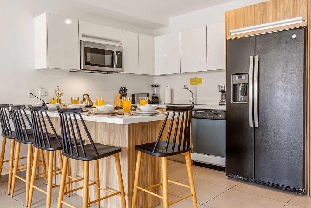 Gather for breakfast at your fully equipped kitchen with sleek modern appliances and a welcoming breakfast bar—perfect for enjoying morning coffee together.