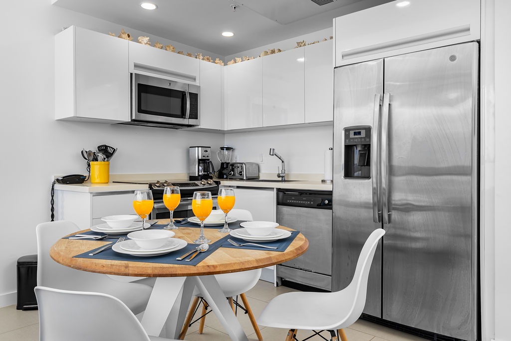 Your bright, fully equipped kitchen makes it easy to prepare and enjoy meals together, with modern appliances and a cozy dining table set for four.