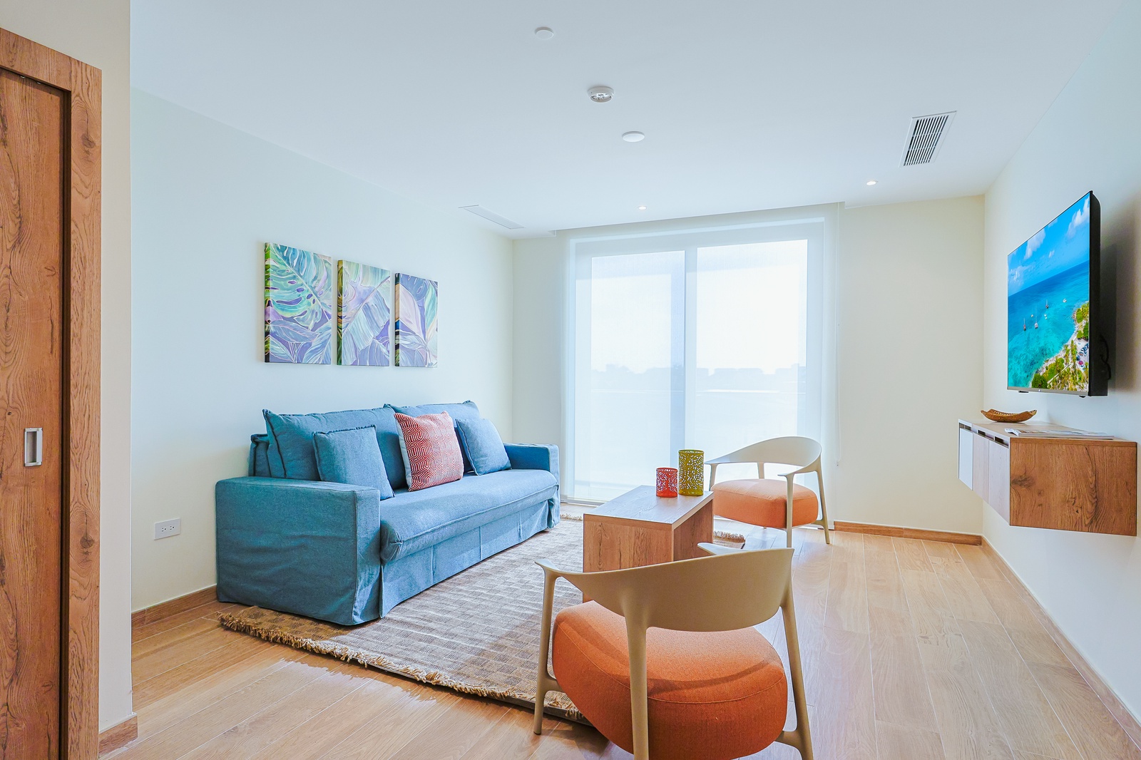 Relax in your bright and airy living space, where pops of color meet modern comfort. Settle into the cozy sofa, enjoy natural light, and unwind with your favorite show after a day of exploring.