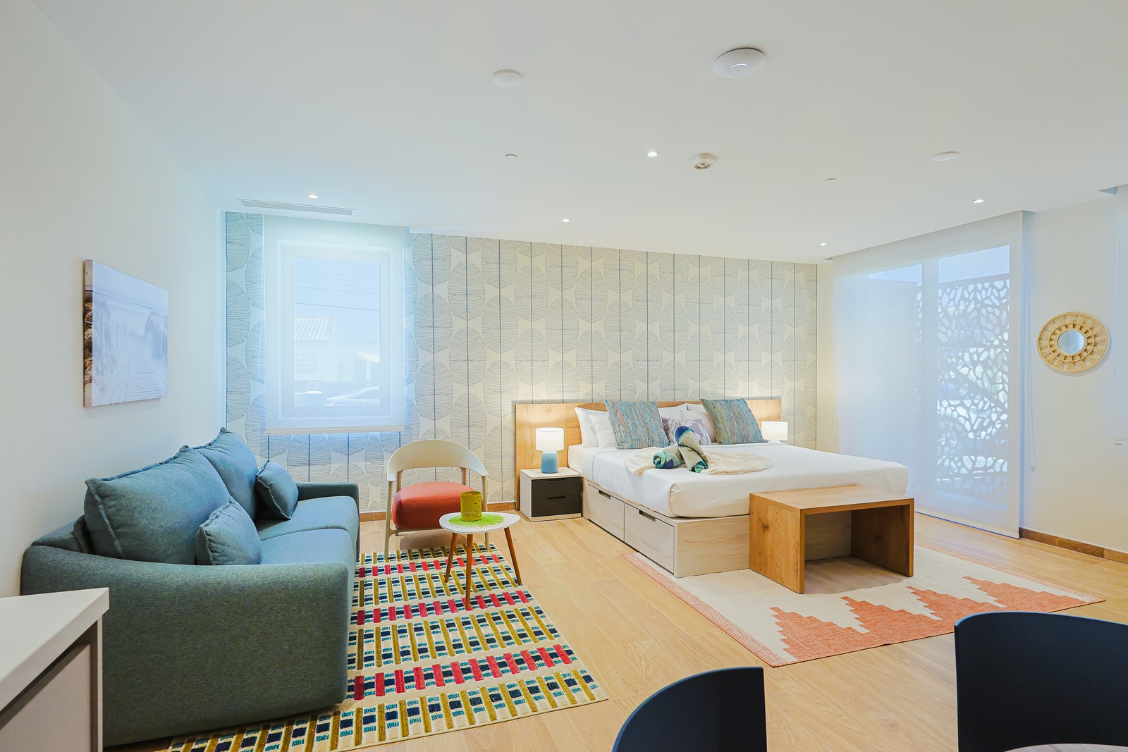 Settle into your bright, airy sanctuary where warm wood floors and soothing coastal hues create an inviting retreat. Sink into plush seating, unwind on your comfortable bed, and enjoy the peaceful ambiance of this modern space.