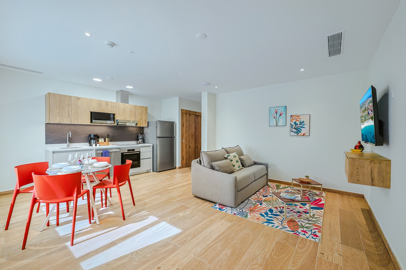 Open, airy living space where you can relax on the plush sofa, share meals at your dining table, and prepare light bites in your well equipped kitchen —all brightened by natural light and thoughtful pops of color.