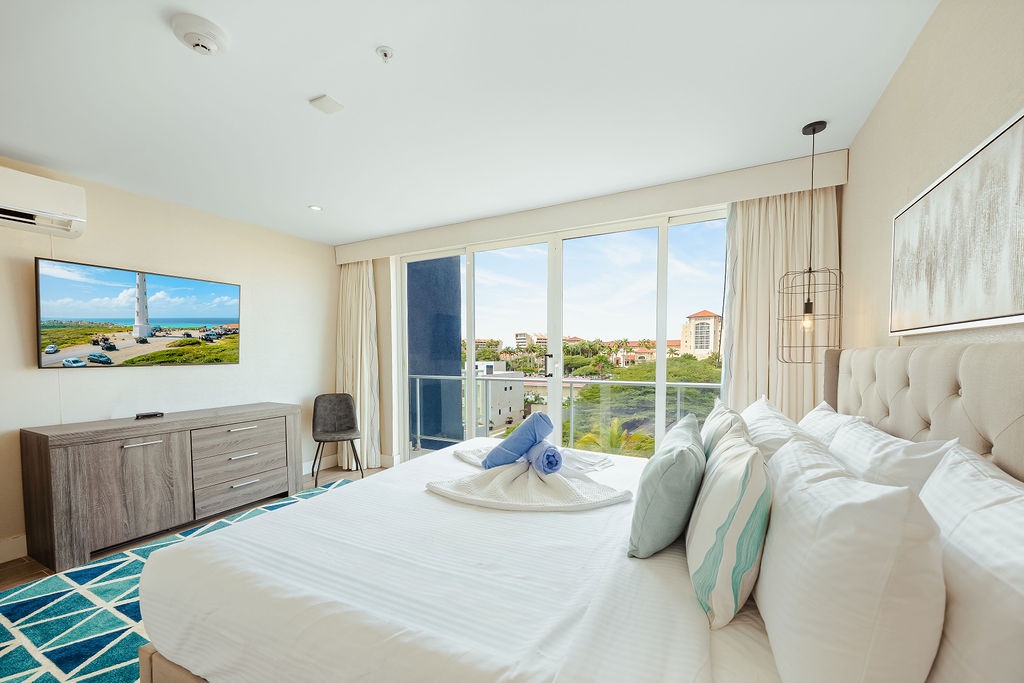 Wake up to stunning city views from your bright, modern bedroom with plush bedding and coastal-inspired décor.