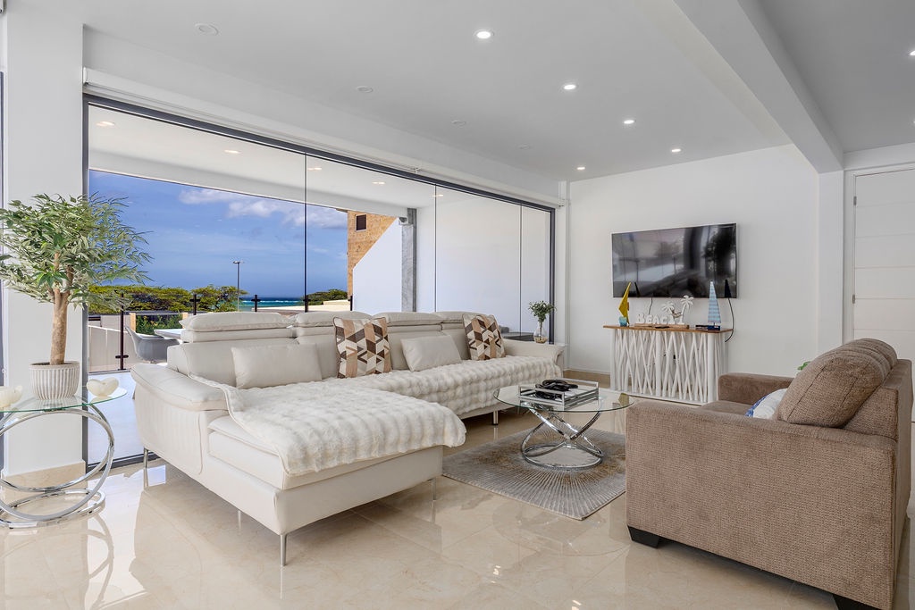 Sink into plush seating and let the ocean breeze drift through your bright, elegant living space—your perfect coastal escape awaits.