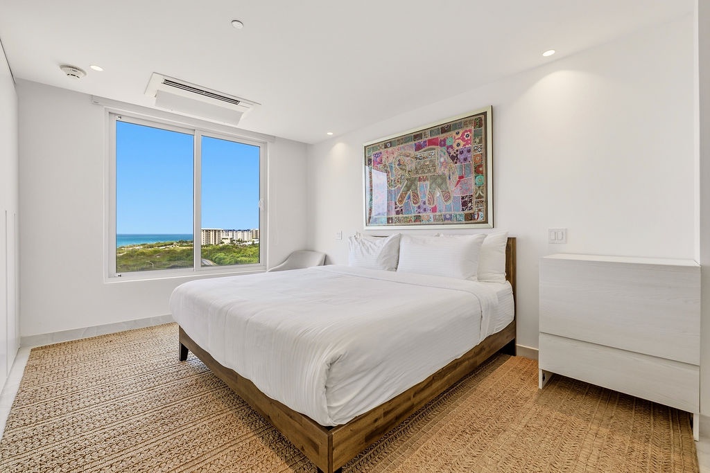 Wake up to stunning ocean and coastal views from your serene bedroom, where crisp white linens and natural textures set the tone for a restful stay.