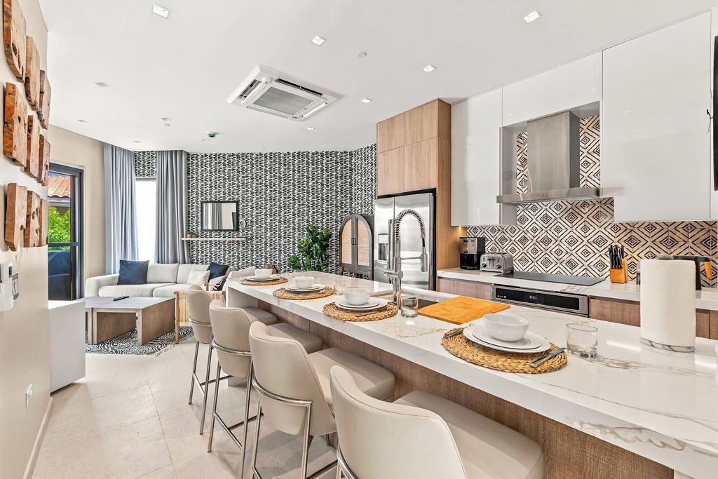 Gather around the sleek island where meals become moments—your open kitchen flows seamlessly into the living space, inviting easy mornings and relaxed evenings in style.