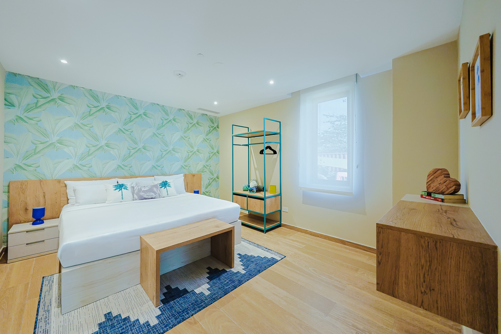 Unwind in your bright, tropical-inspired bedroom with soft linens, natural wood accents, and serene palm leaf details for a refreshing coastal retreat.
