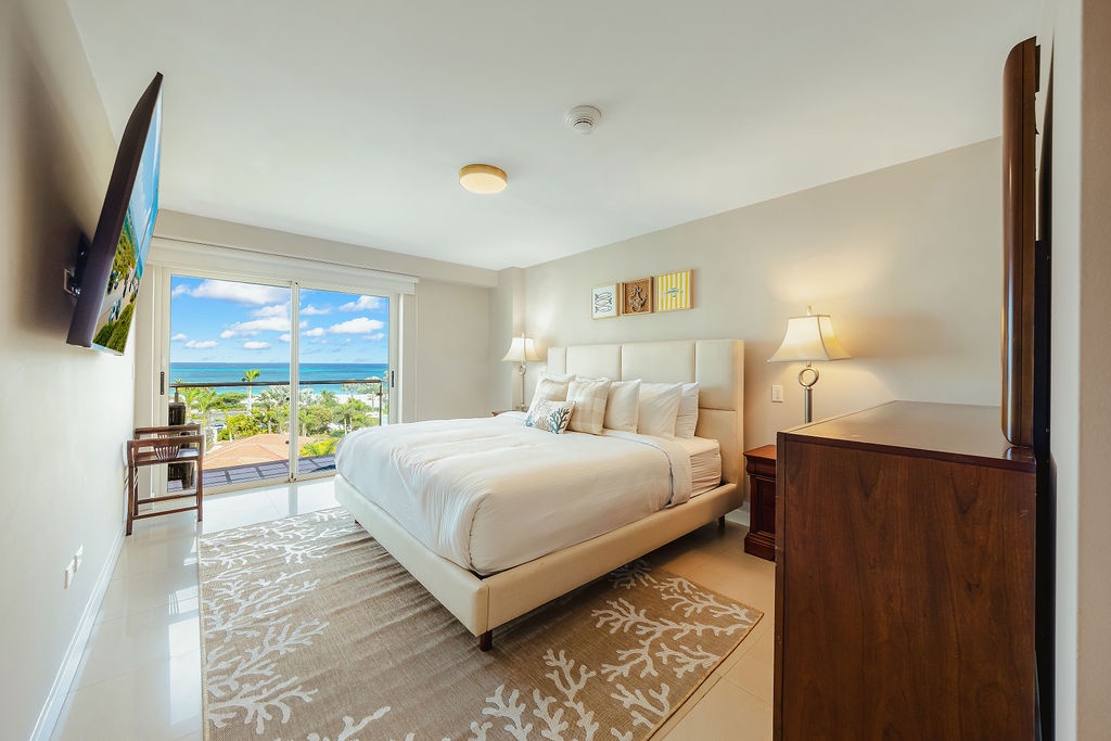 Wake up to stunning ocean vistas just beyond your glass doors. Your serene bedroom retreat features a plush bed, coastal-inspired touches, and direct access to a private balcony overlooking the sparkling sea.