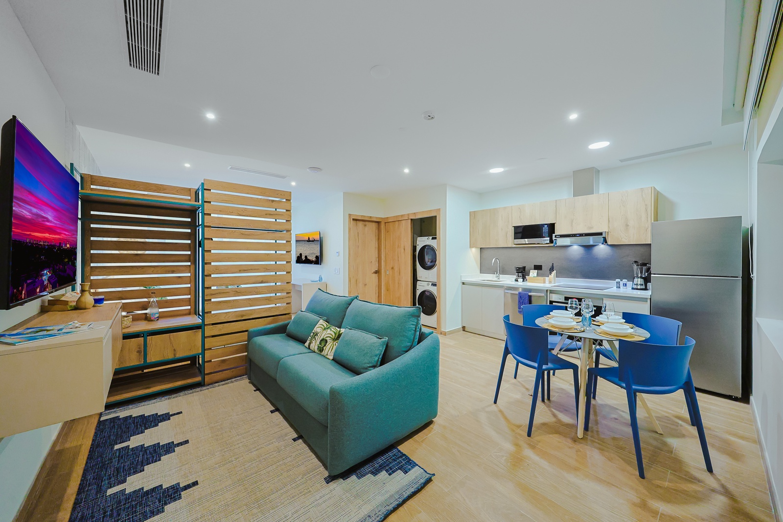 Your spacious open-concept retreat seamlessly blends living, dining, and kitchen spaces with contemporary comfort and vibrant pops of color throughout.