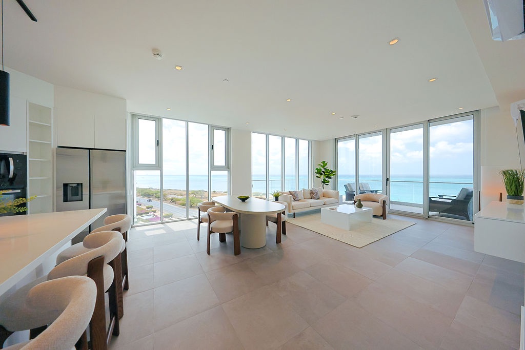 Unwind in this stunning oceanfront living space where floor-to-ceiling windows frame endless sea views, creating your perfect coastal retreat.