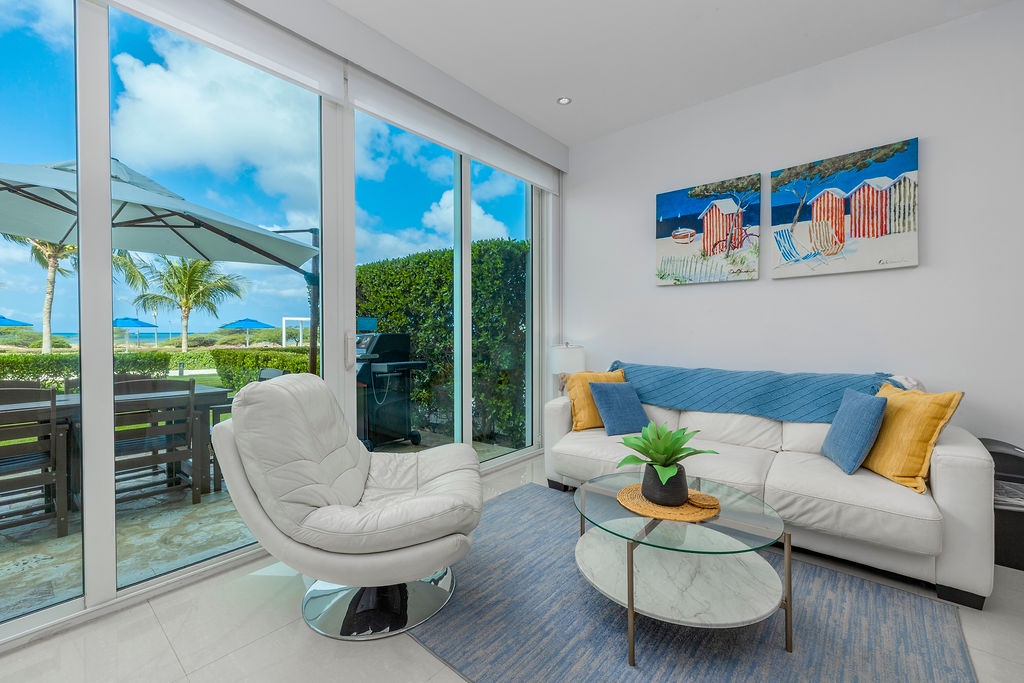 Sink into plush seating while enjoying tropical ocean views through floor-to-ceiling windows in your bright, modern living space.