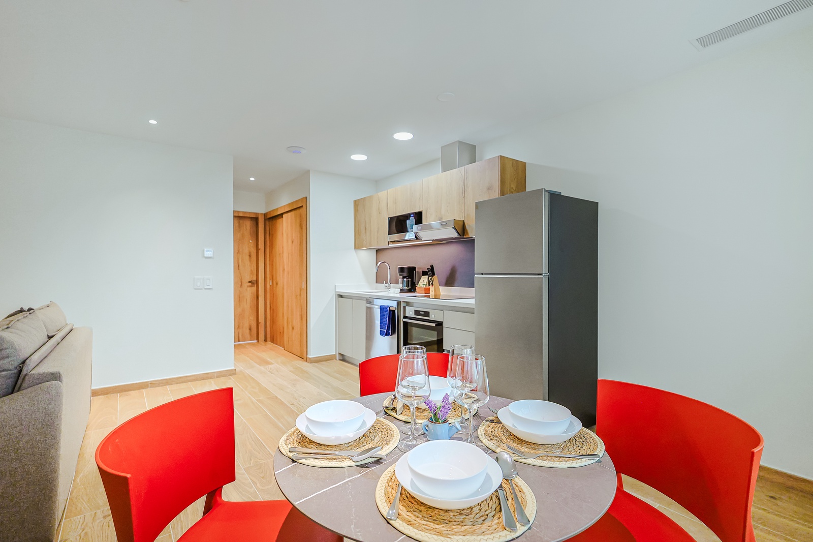 Gather around the sleek dining table set for four, with your bright modern kitchen just steps away—everything you need for effortless meals at home.