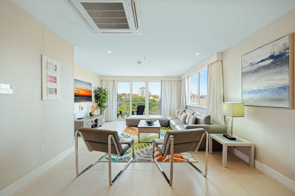 Your bright living space welcomes you with modern comfort, stylish seating, and peaceful views through floor-to-ceiling windows.