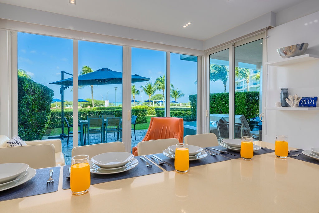 Start your day with fresh orange juice at your dining table while soaking in stunning pool and tropical views through floor-to-ceiling windows.