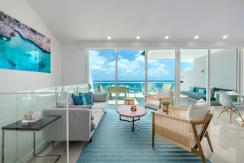 Sink into the plush sofa and let the endless ocean views wash over you. This bright, airy living space invites you to unwind in style with coastal-chic décor.