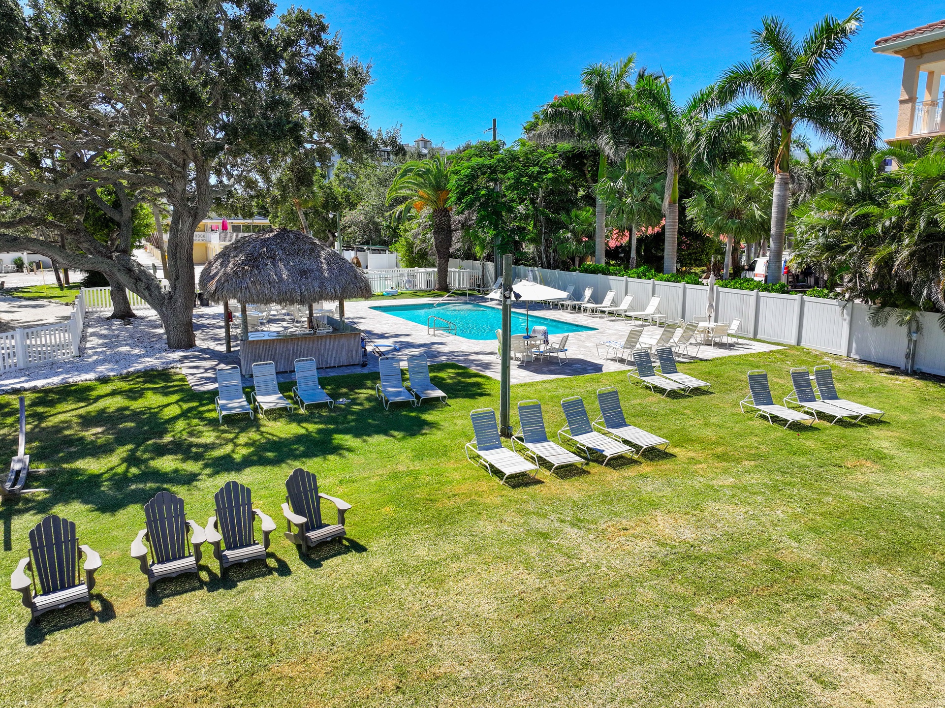 Soak up the sun on your private lounger by the pool, shaded by swaying palms and a thatched tiki hut. This lush tropical oasis invites you to unwind with a book or take a refreshing dip whenever you please.
