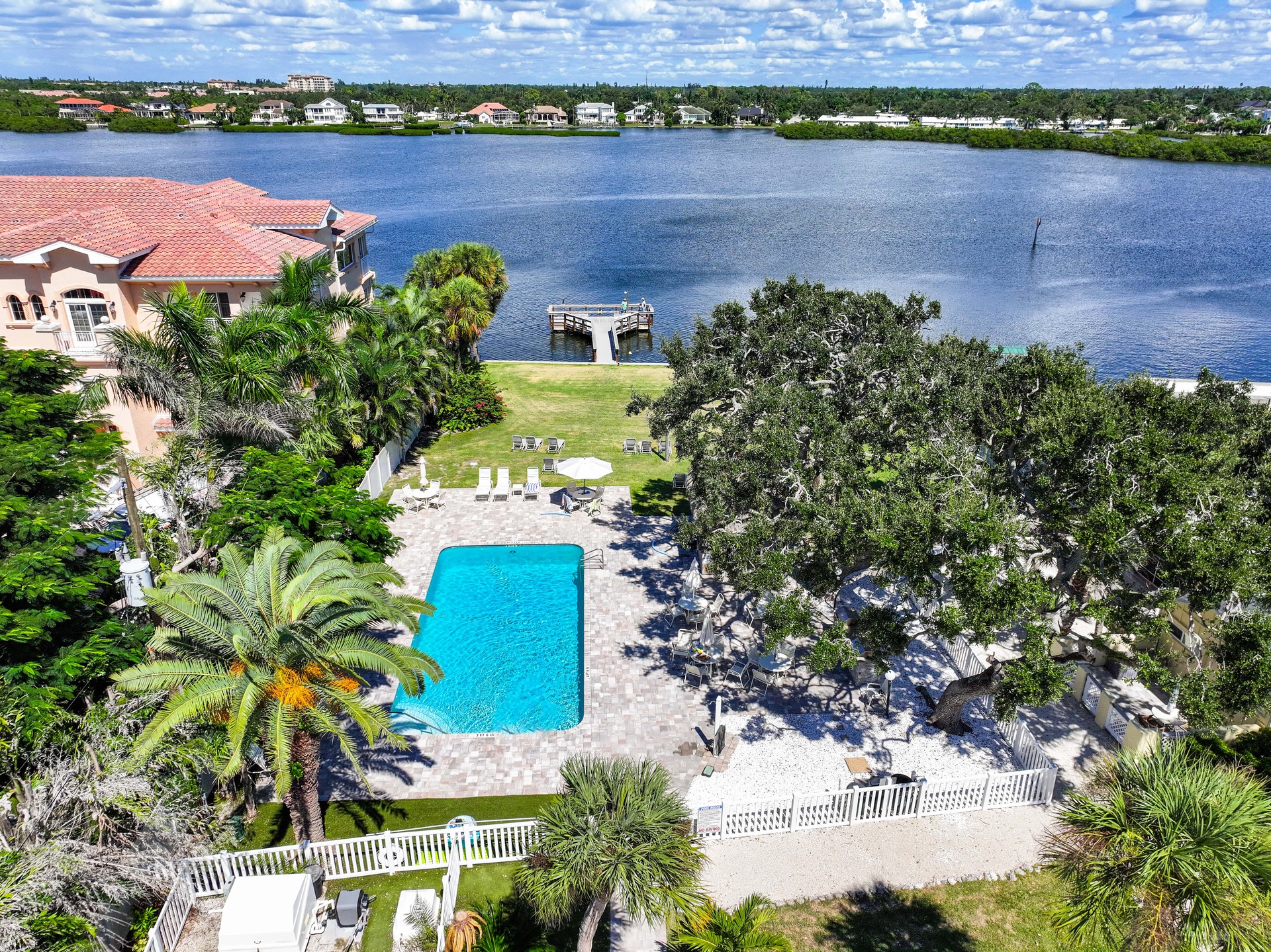 Luxurious waterfront retreat featuring a private pool, dock access, and serene lakefront setting surrounded by lush tropical landscaping.