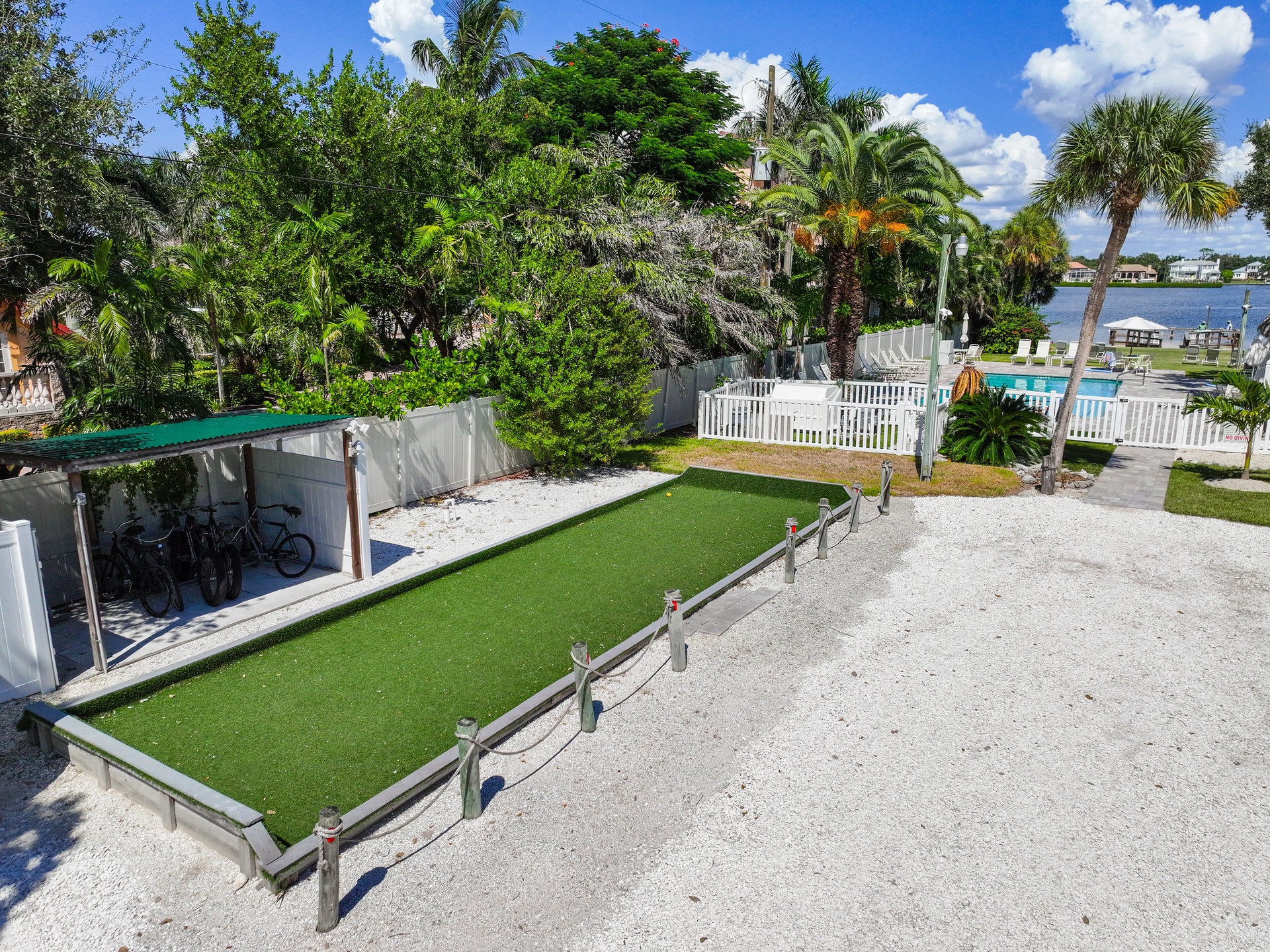 The property features lush tropical grounds with a waterfront setting, offering a serene outdoor escape surrounded by palm trees and landscaped gardens.