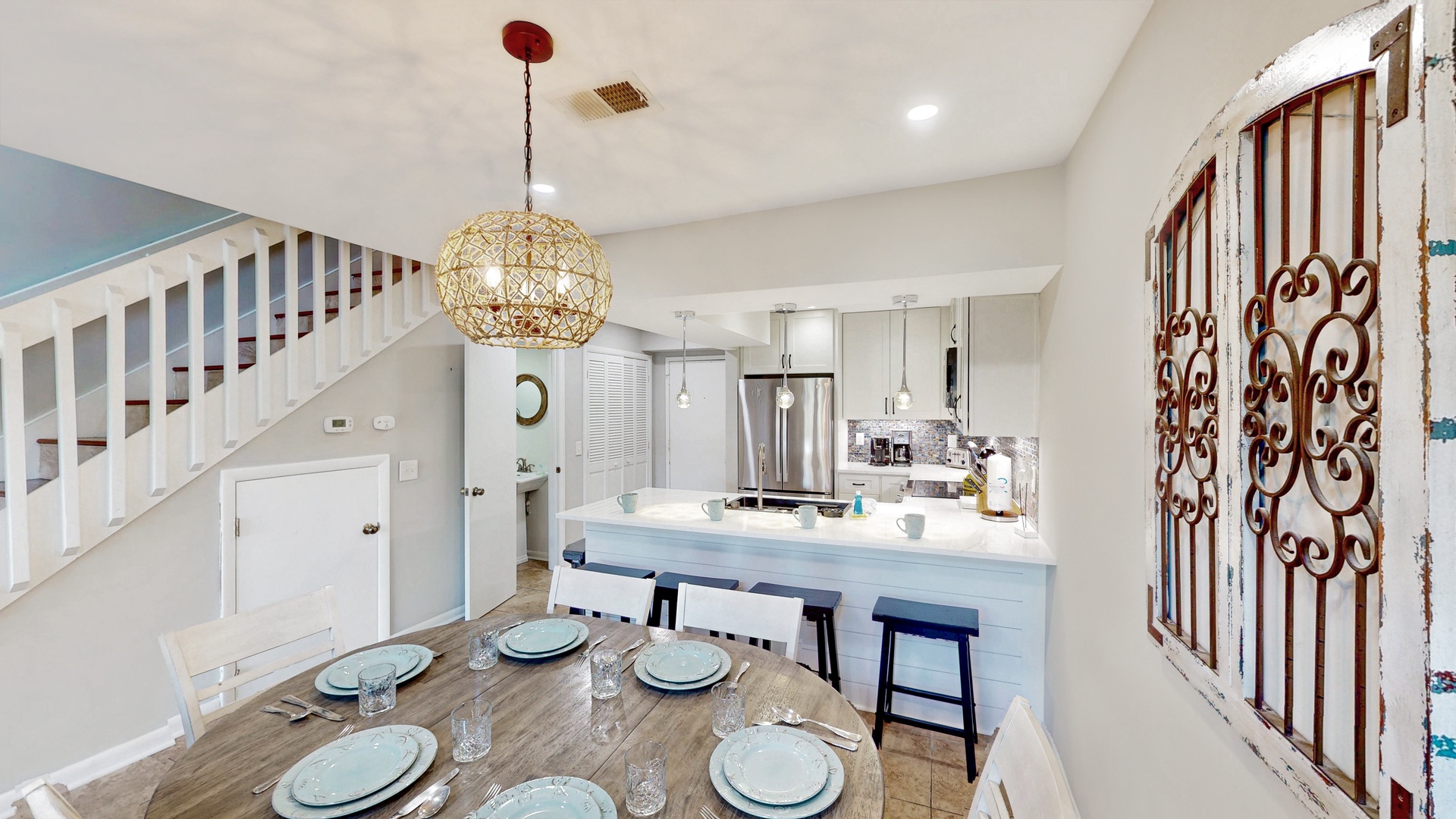 You'll love gathering around this bright, coastal-inspired dining and kitchen space. The open layout and charming touches create a welcoming spot for meals together.