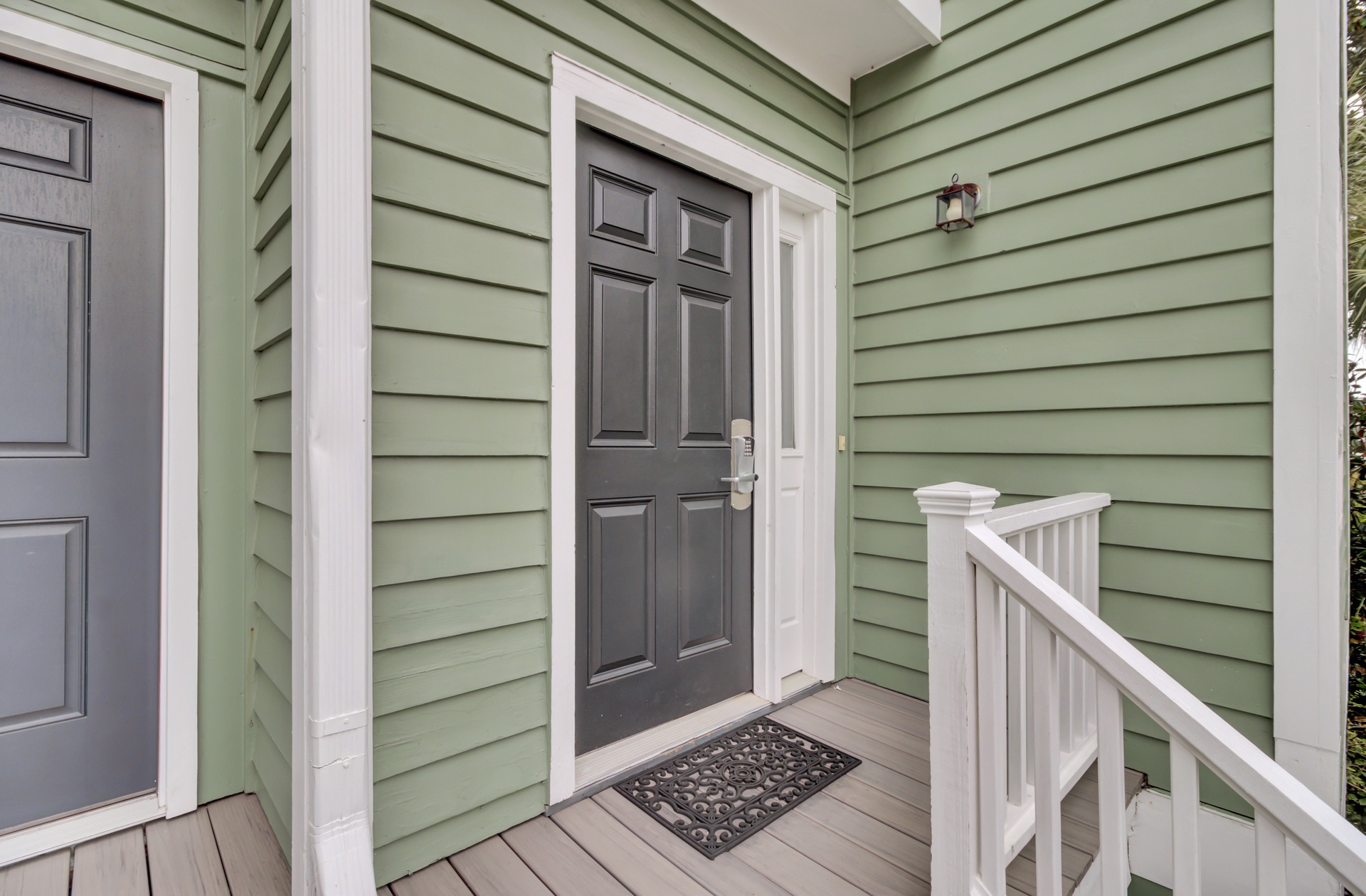 Charming green cottage entrance with classic details and welcoming covered porch creates an inviting first impression.