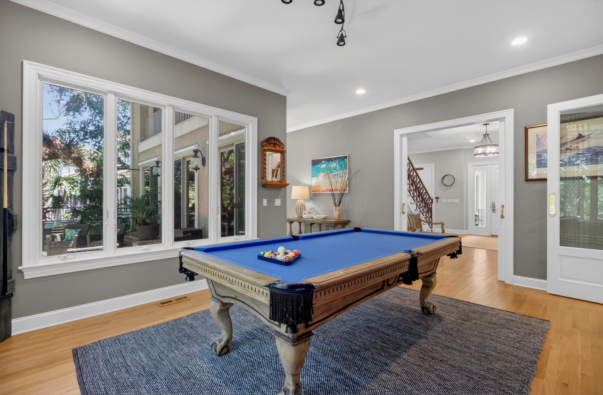 Your private game room awaits with a classic billiards table, perfect for friendly competition and evening entertainment in this elegant, light-filled space.