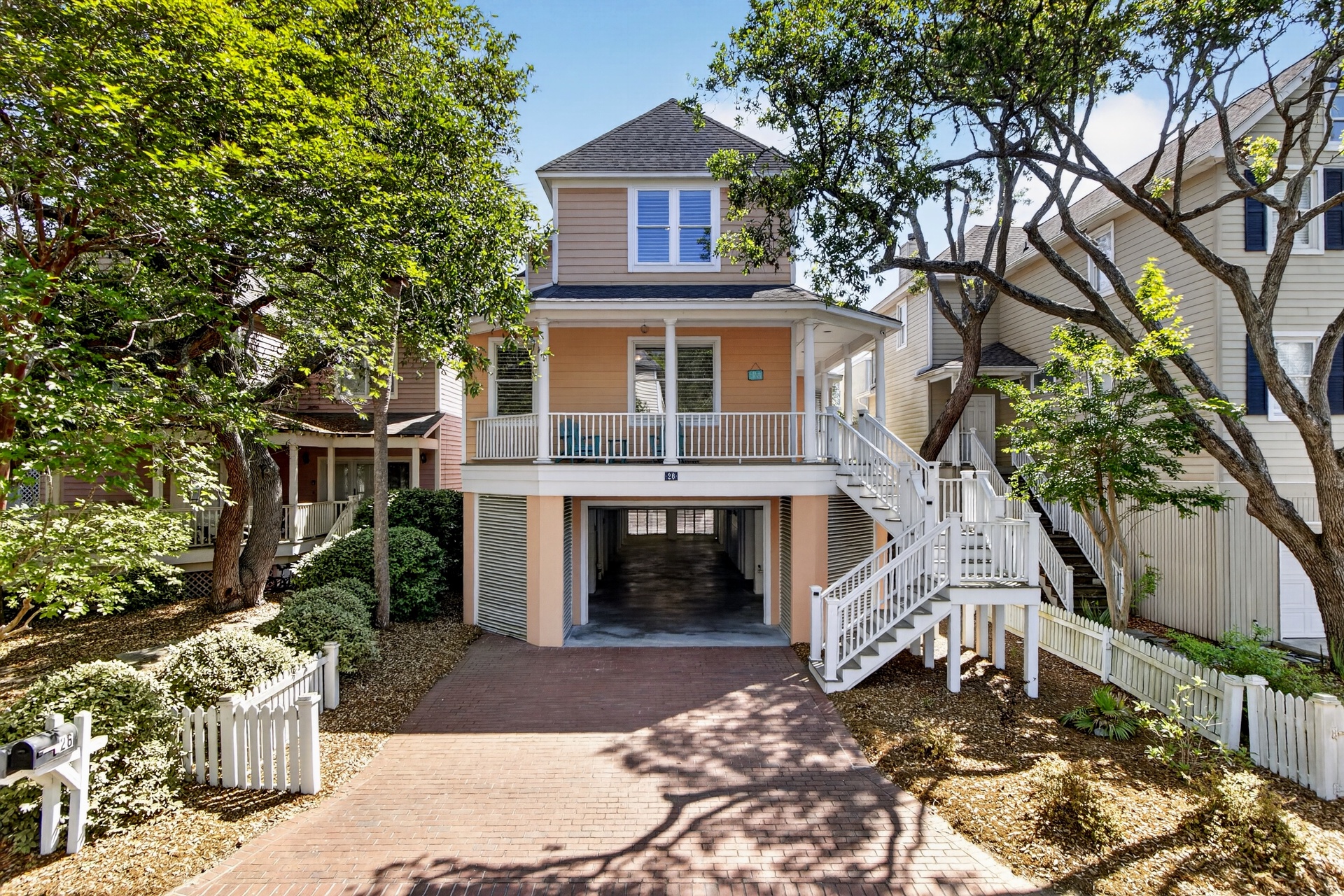 Charming coastal property nestled among mature trees with covered parking and stairs leading to your elevated beach retreat.