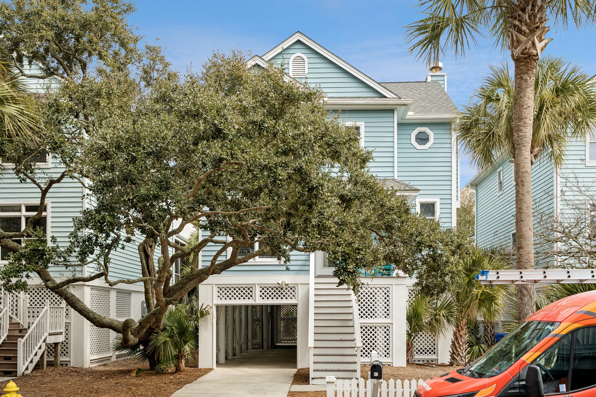 Charming coastal cottage with tropical landscaping and convenient covered parking in a peaceful residential setting.