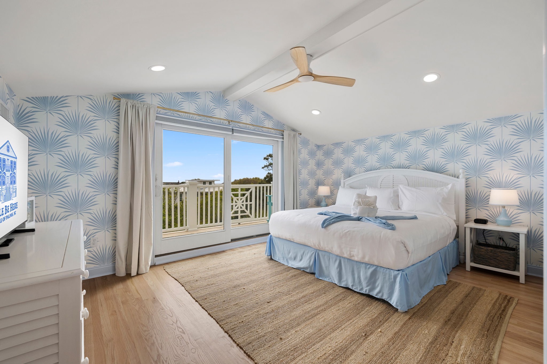 Drift to sleep in your coastal haven with tropical palm wallpaper and natural light streaming through doors to your private balcony.