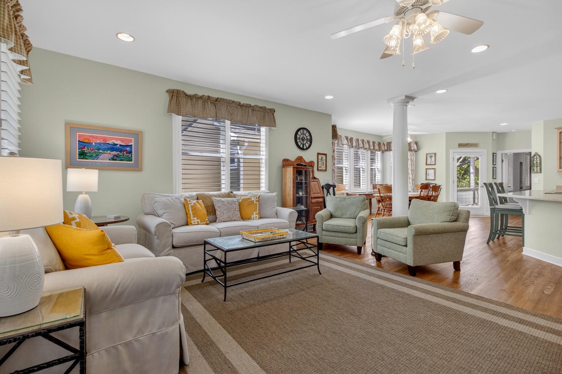 Sink into plush sofas in your spacious living room, where golden accents and coastal art create the perfect retreat atmosphere.