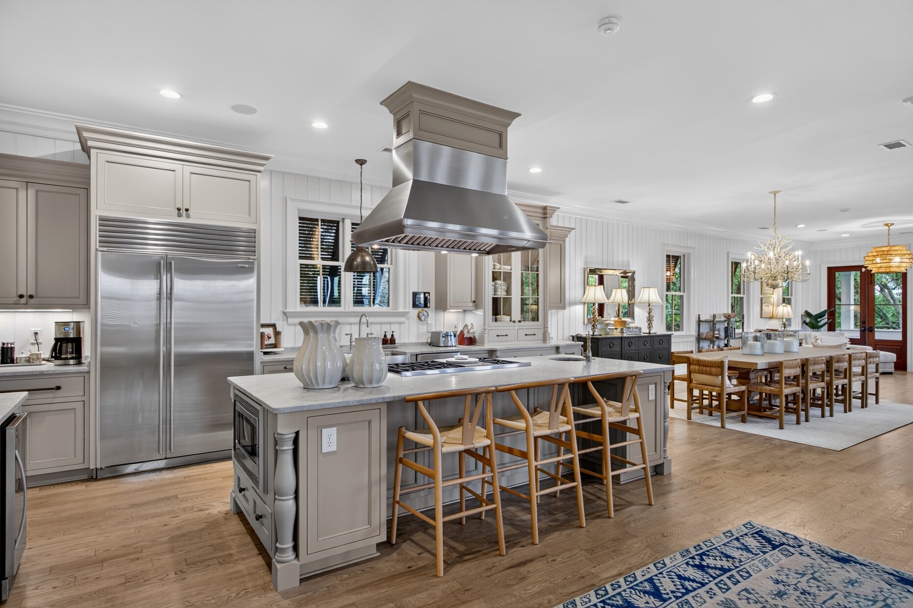 Prepare your favorite meals in this stunning chef's kitchen, complete with premium stainless steel appliances, spacious marble island with seating, and elegant flow into your inviting dining space.