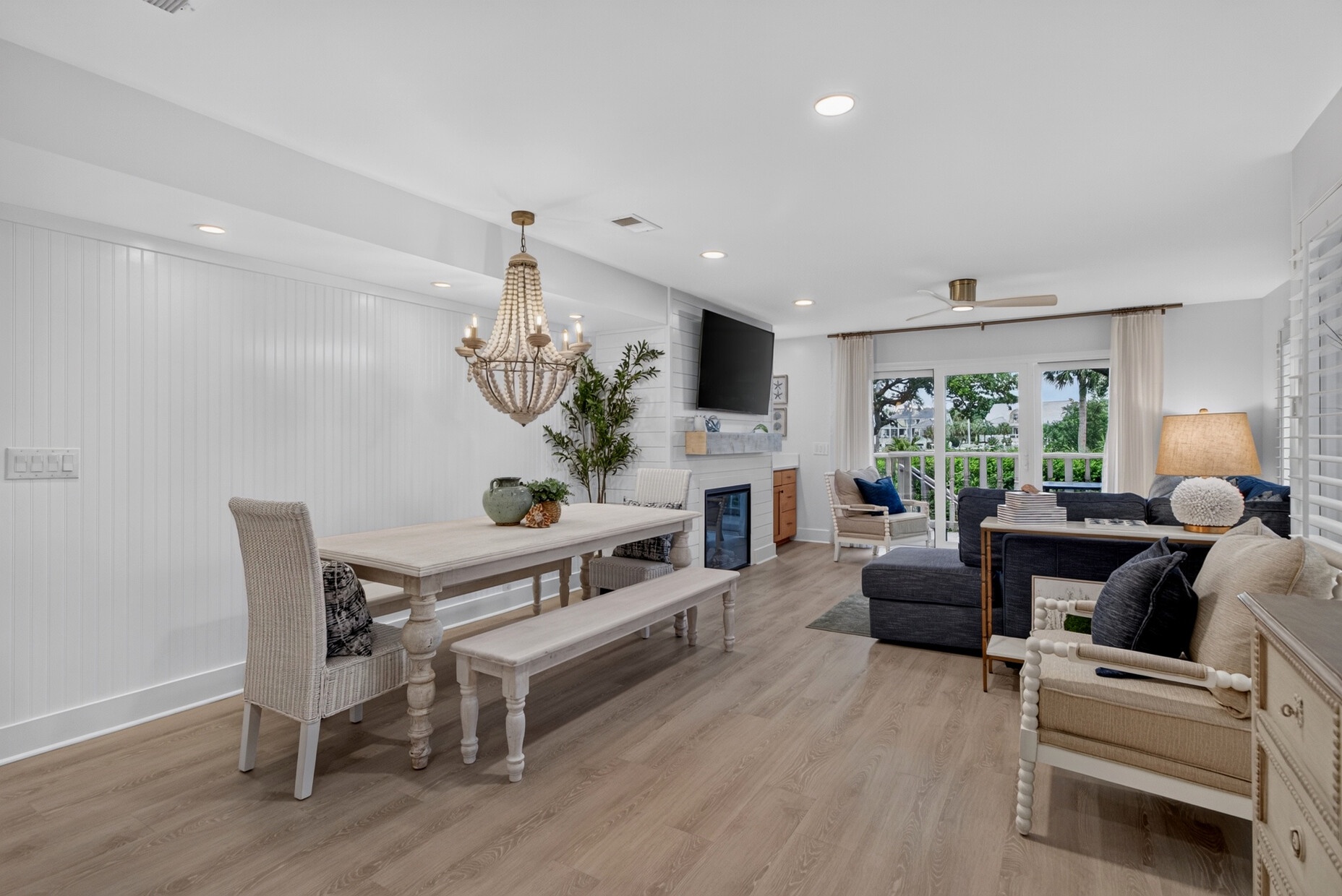 Relax in this bright, open-concept space where coastal charm meets modern comfort. Enjoy meals at the rustic dining table, unwind on plush seating, and step out to your private outdoor retreat through elegant French doors.