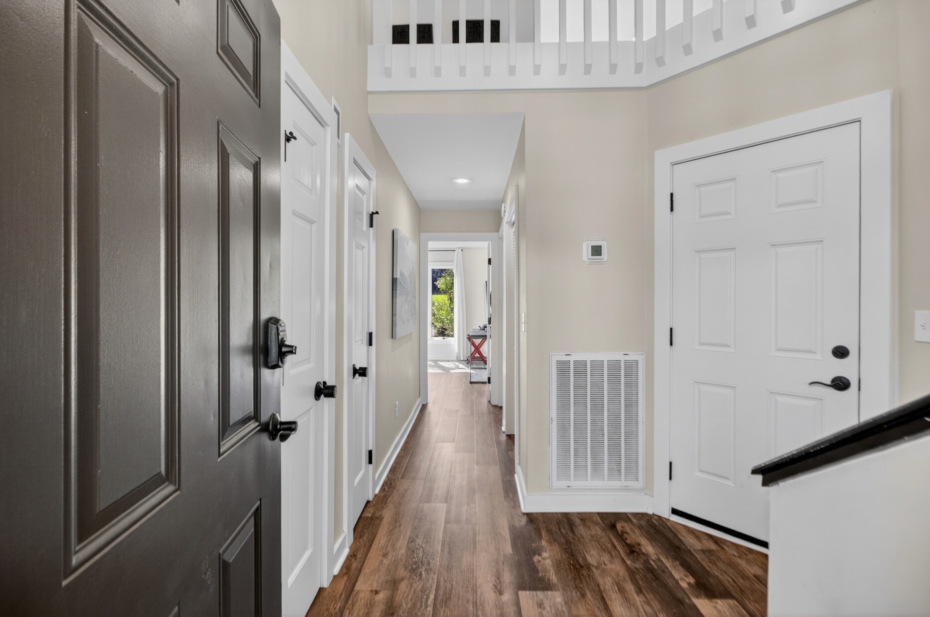 Step through the front door into your bright, welcoming hallway with gleaming wood floors leading you to comfortable living spaces and sunny outdoor views ahead.
