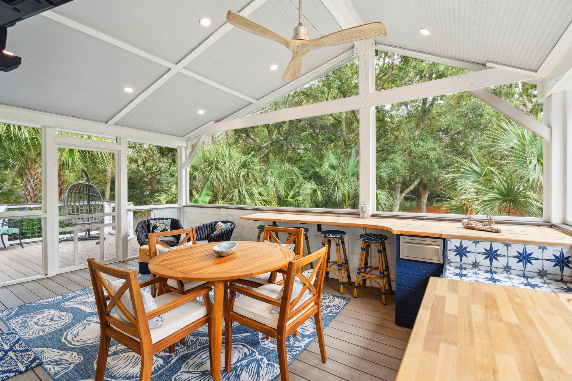 Sip your morning coffee surrounded by lush tropical views in this screened dining space. The breezy bar seating and cozy table invite you to gather and unwind.