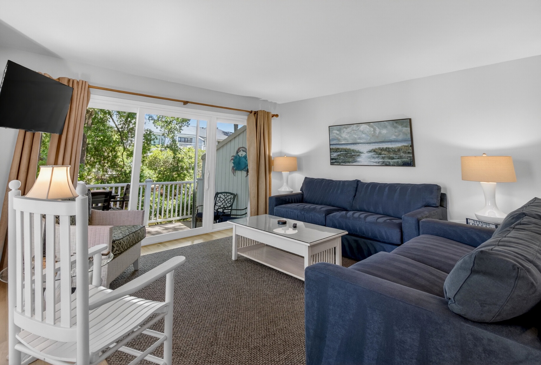 Sink into plush navy sofas in your bright living space, where natural light streams through sliding doors to your private balcony retreat.