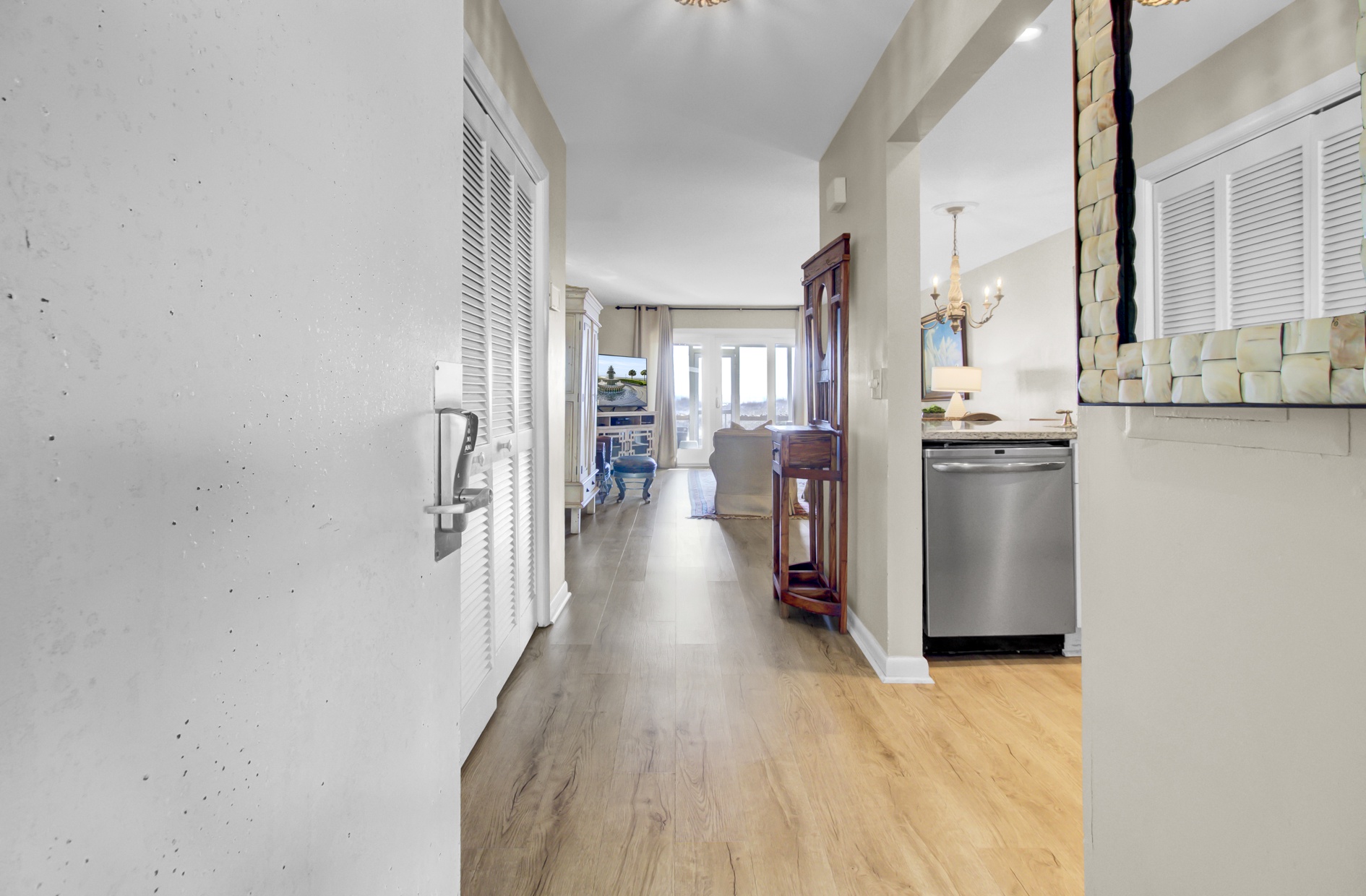 Step into your bright, open-concept space where elegant hardwood flows seamlessly from kitchen to living area, creating the perfect backdrop for your coastal getaway.