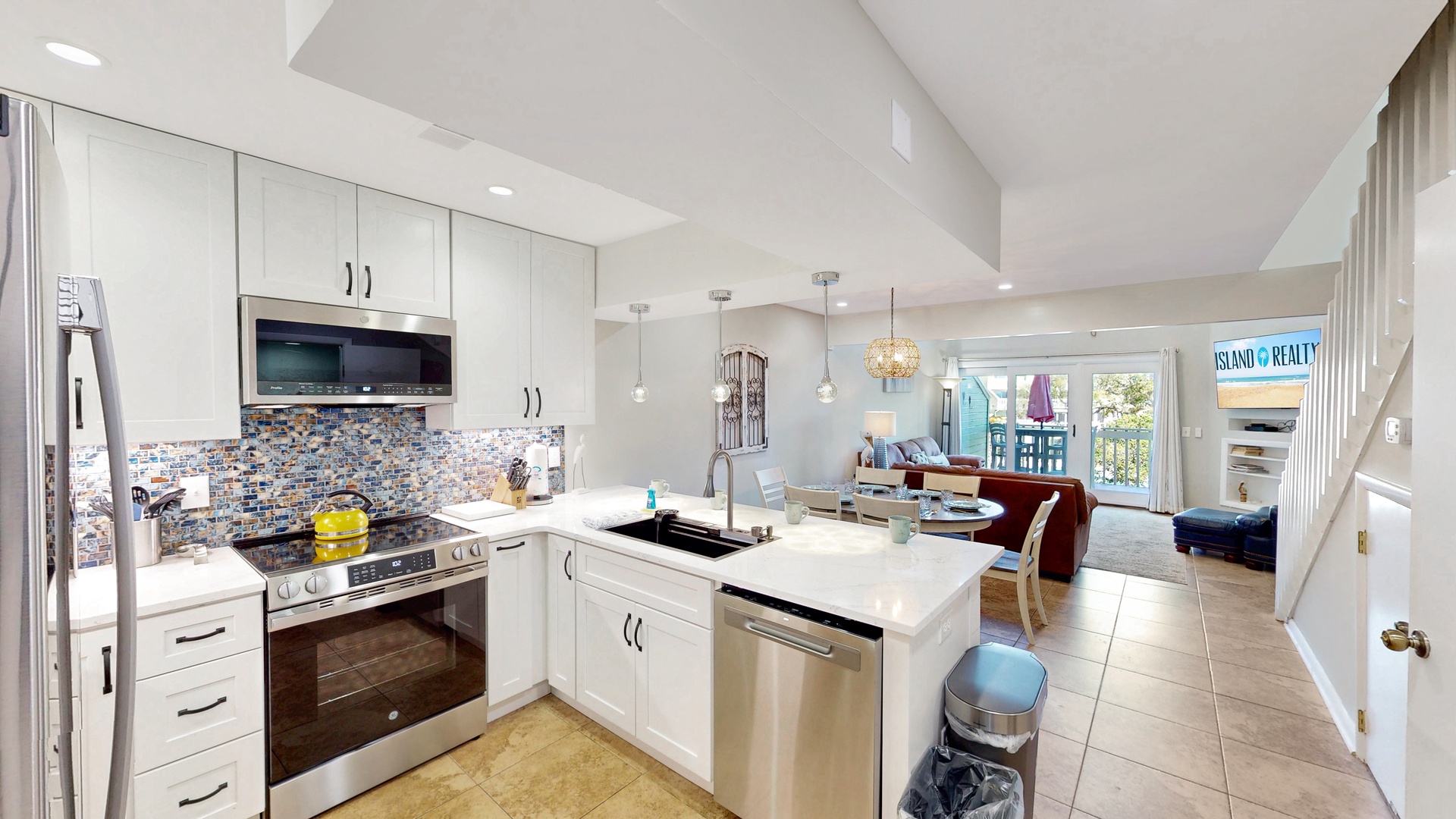 Your fully equipped kitchen opens to an inviting living space, perfect for preparing meals while staying connected with family and friends throughout your beach getaway.