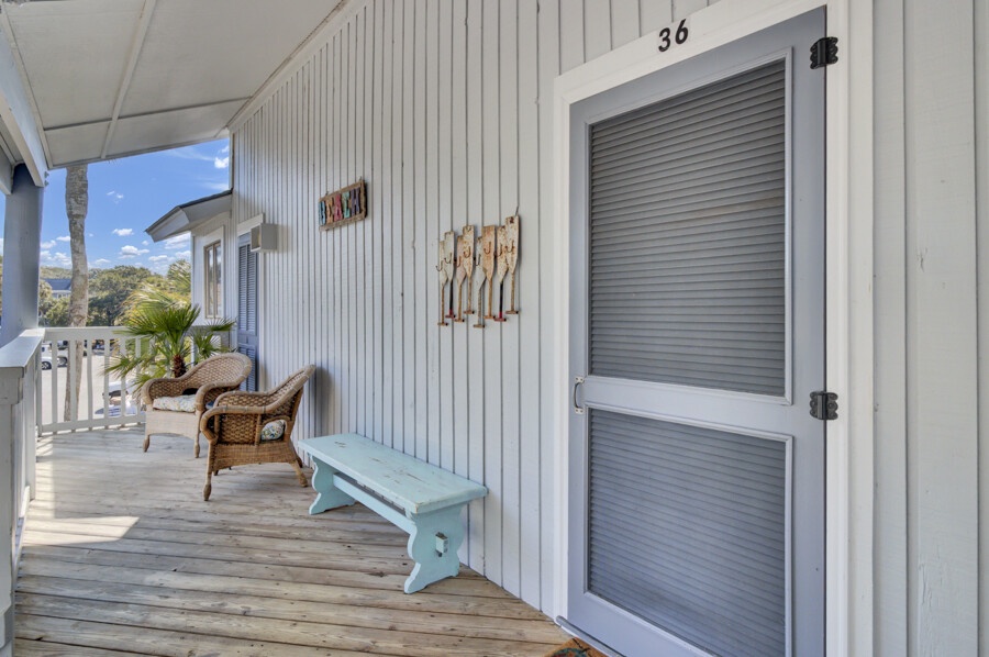 Your private balcony awaits with wicker seating and coastal charm, perfect for morning coffee while taking in those stunning tropical views.
