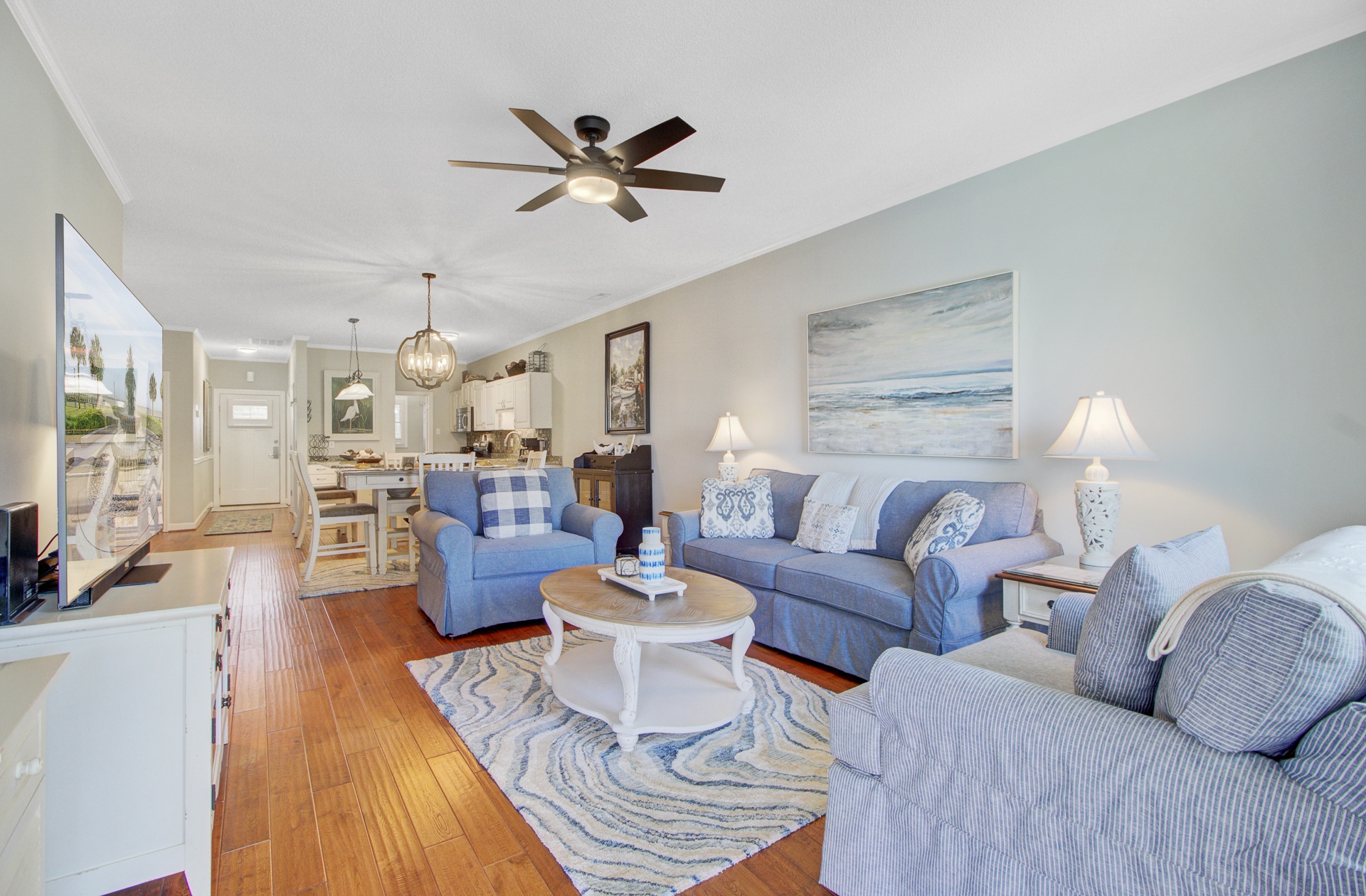 Sink into coastal comfort in your spacious living area, where soft blue furnishings and ocean-inspired artwork create the perfect beach retreat.