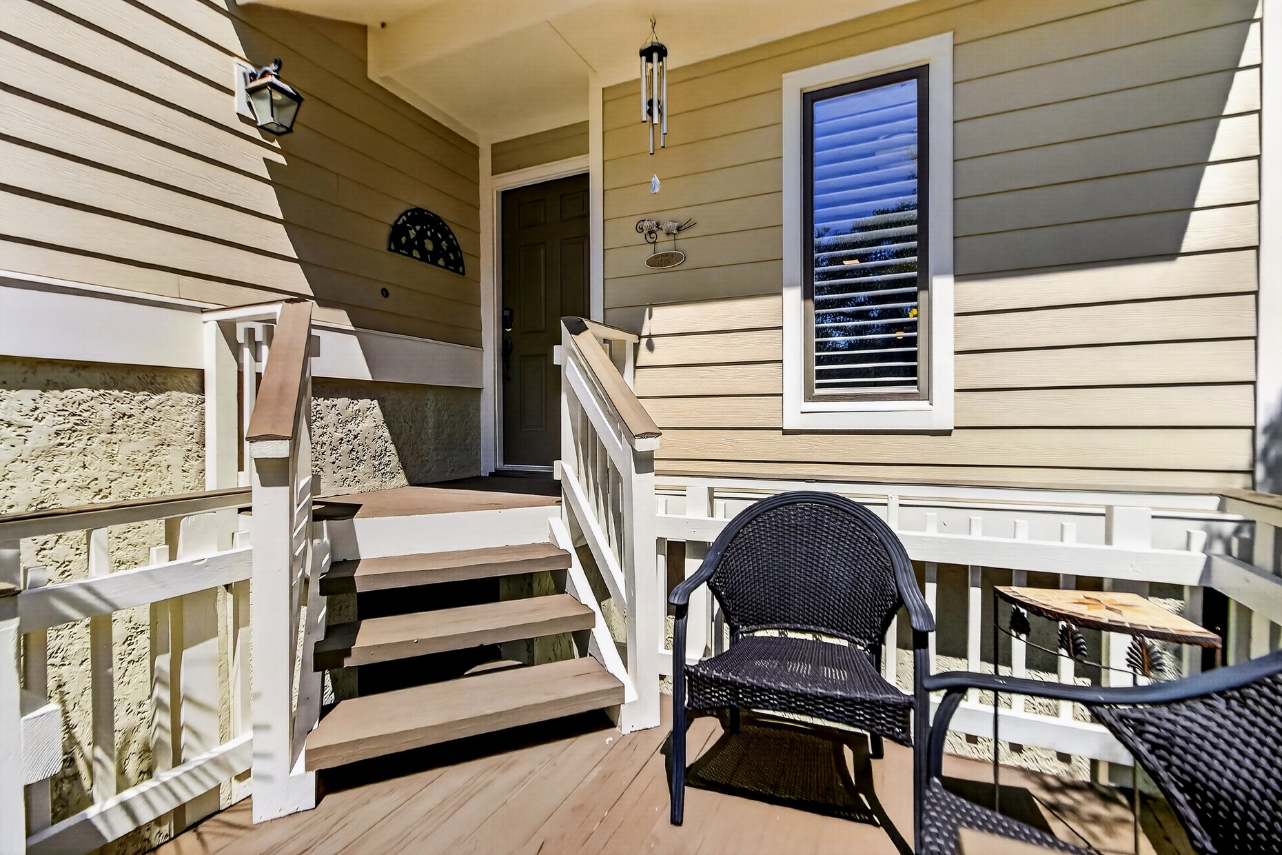 Step onto your private balcony, where comfortable wicker seating invites you to unwind with a book or morning coffee, while the coastal breeze drifts through this peaceful outdoor retreat.