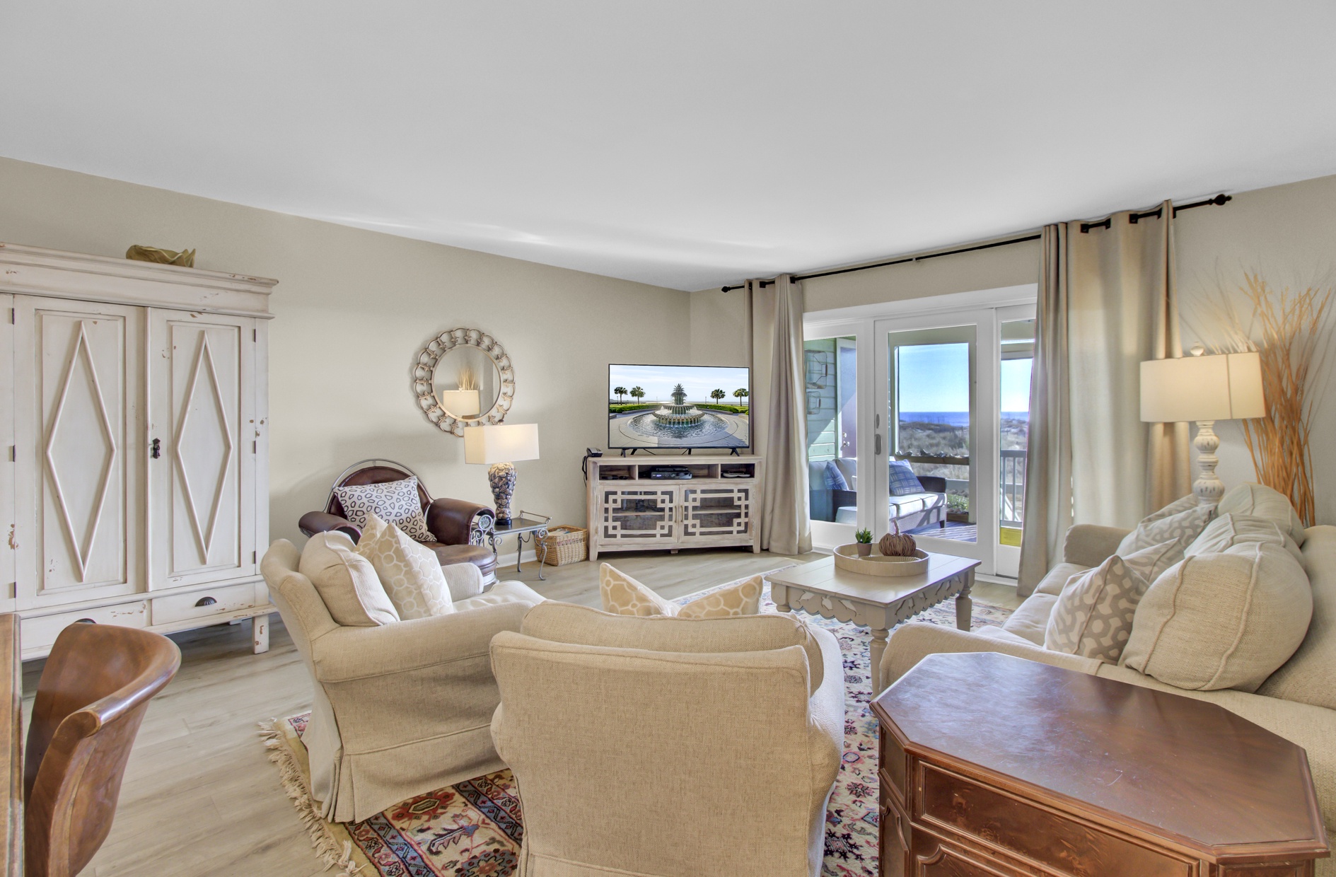 Settle into your bright, welcoming living room where beige tones create warmth and ocean views through sliding doors invite relaxation.